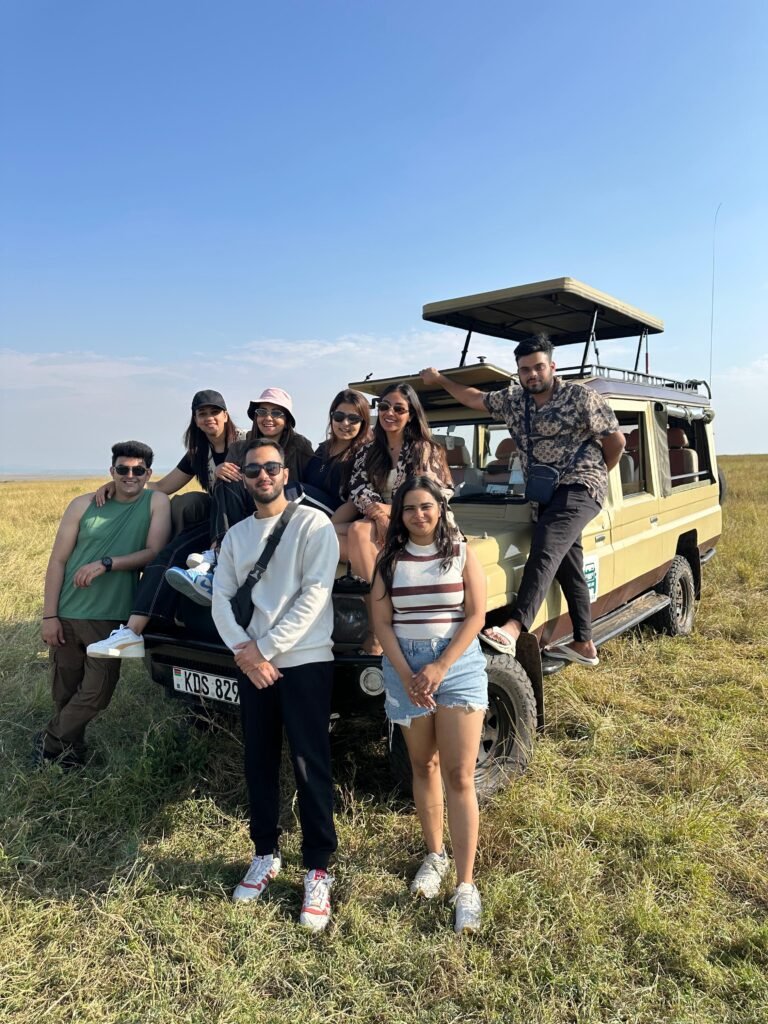 Safari Lab guests beside their safari vehicle in the Masai Mara